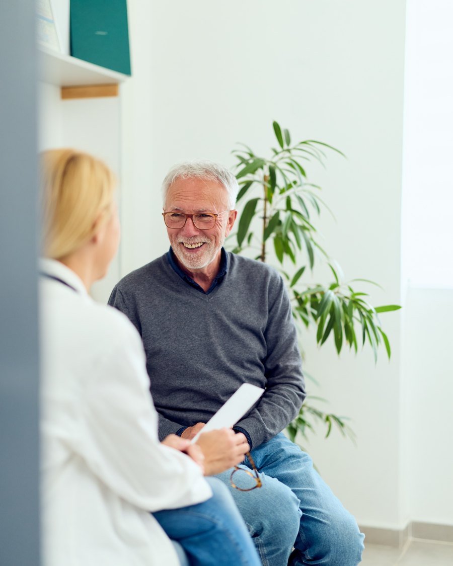 A clinician talking with a patient in an exam room