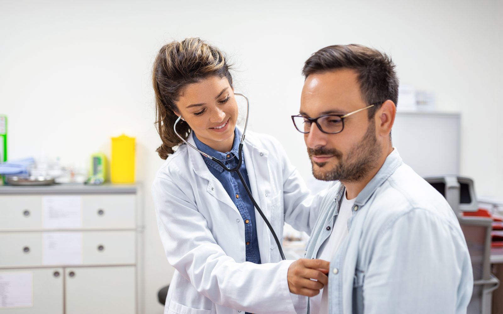 A clinician listening to a patient’s heart with a stethoscope during a routine office visit